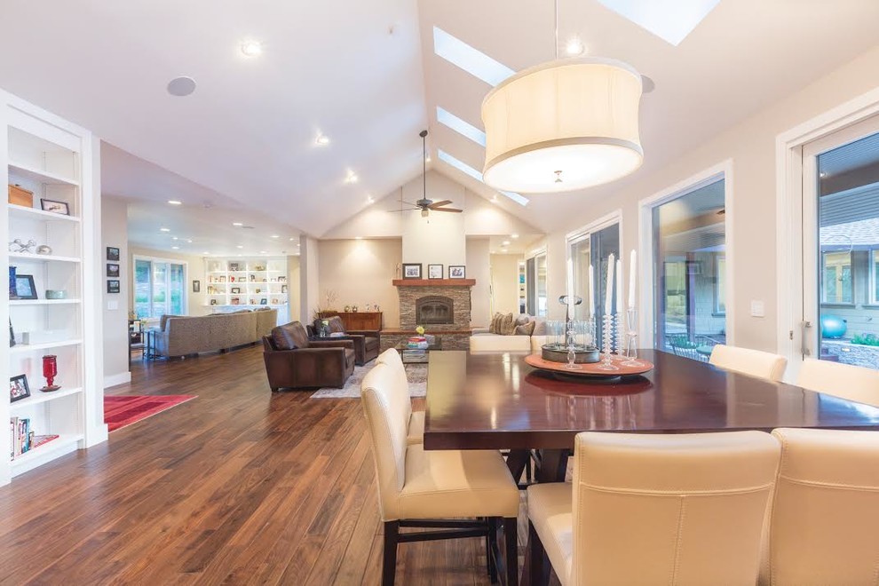 Inspiration for a large transitional medium tone wood floor and brown floor great room remodel in Detroit with beige walls, a standard fireplace and a stone fireplace