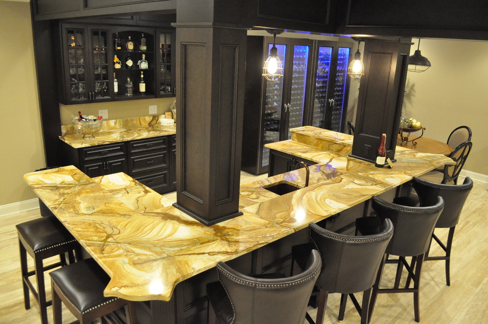 Large traditional u-shaped seated home bar in Atlanta with an undermount sink, raised-panel cabinets, dark wood cabinets, onyx benchtops, beige splashback and light hardwood floors.