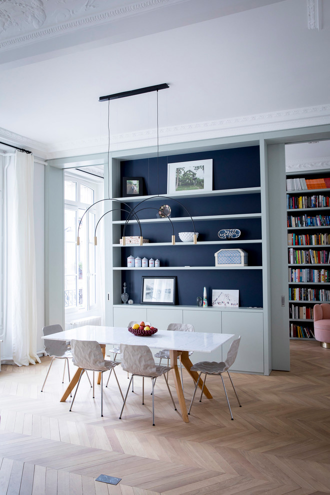 Design ideas for a contemporary dining room in Paris with white walls, light hardwood floors and beige floor.