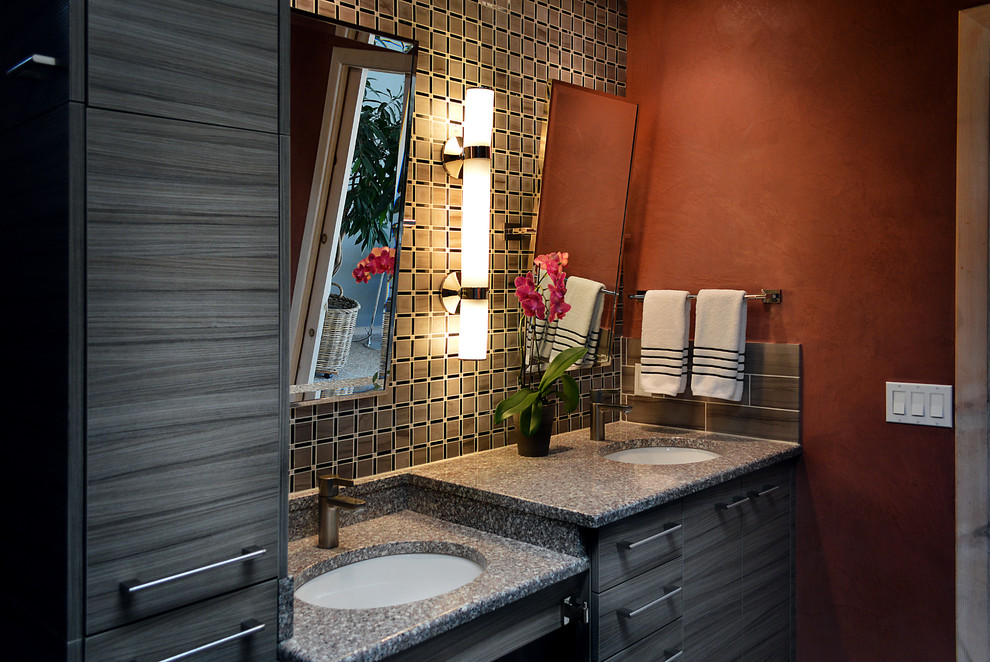 This is an example of a large modern master bathroom in Albuquerque with a drop-in sink, flat-panel cabinets, medium wood cabinets, granite benchtops, an alcove shower, a two-piece toilet and orange walls.