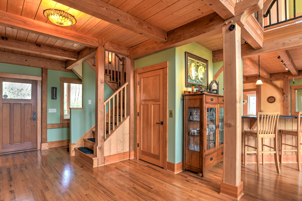 Mid-sized country foyer in Charlotte with green walls, medium hardwood floors, a single front door and a medium wood front door.
