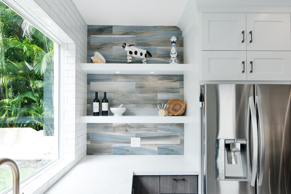 Open concept kitchen - mid-sized transitional u-shaped porcelain tile and gray floor open concept kitchen idea in Miami with a farmhouse sink, shaker cabinets, white cabinets, quartz countertops, stainless steel appliances, a peninsula and white countertops
