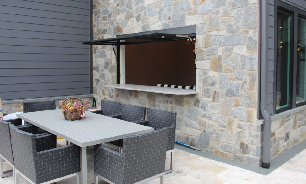 This is an example of a large transitional two-storey house exterior in DC Metro with stone veneer.