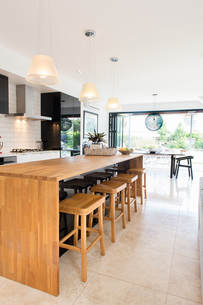 Design ideas for a transitional kitchen in Brisbane with flat-panel cabinets, black cabinets, white splashback, subway tile splashback and with island.