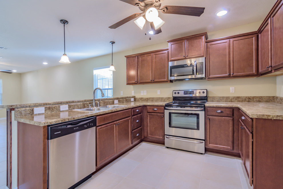 Example of a mid-sized arts and crafts u-shaped ceramic tile and beige floor eat-in kitchen design with a double-bowl sink, recessed-panel cabinets, medium tone wood cabinets, stainless steel appliances and no island