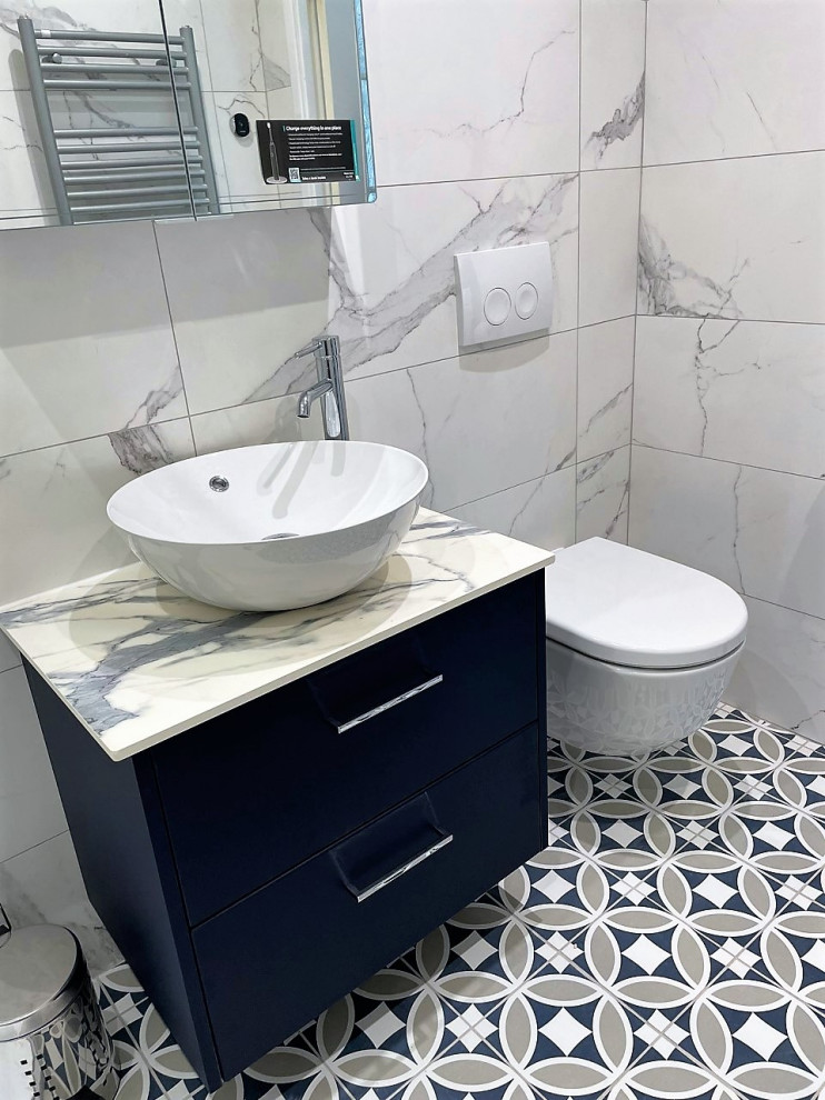 Mid-sized modern master bathroom in Other with flat-panel cabinets, blue cabinets, an open shower, a wall-mount toilet, white tile, porcelain tile, porcelain floors, a vessel sink, laminate benchtops, multi-coloured floor, an open shower, white benchtops, a niche, a single vanity and a floating vanity.