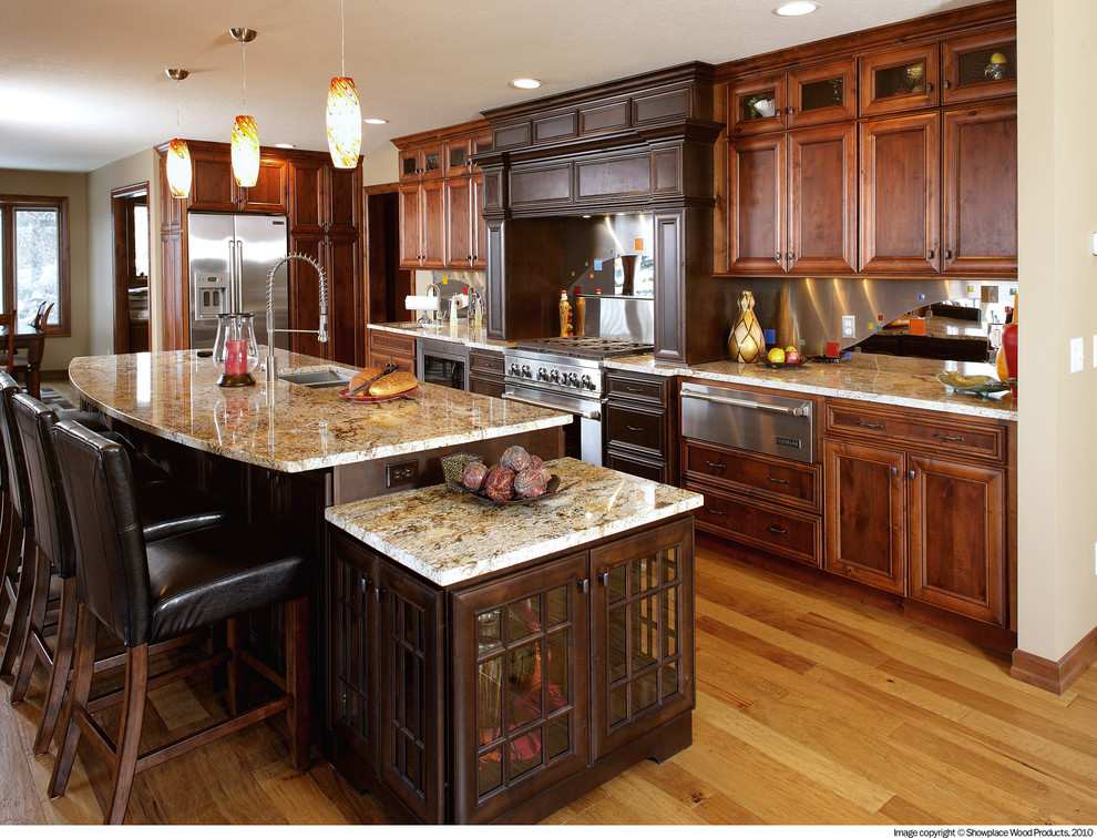 Inspiration for a transitional u-shaped medium tone wood floor open concept kitchen remodel with a double-bowl sink, raised-panel cabinets, dark wood cabinets, granite countertops, white backsplash, stainless steel appliances and an island