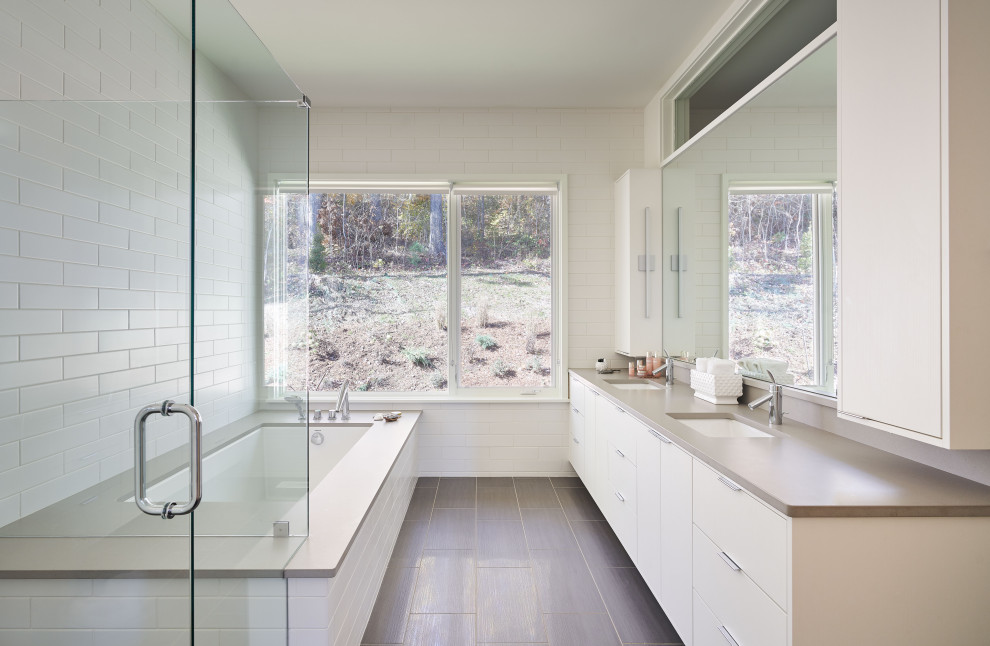 Inspiration for a large contemporary master bathroom in Other with flat-panel cabinets, white cabinets, an undermount tub, a corner shower, white tile, subway tile, an undermount sink, brown floor, a hinged shower door and beige benchtops.