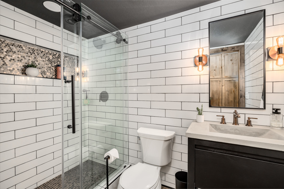 Design ideas for a mid-sized transitional 3/4 bathroom in Other with flat-panel cabinets, black cabinets, an alcove shower, a one-piece toilet, white tile, subway tile, white walls, porcelain floors, an integrated sink, concrete benchtops, brown floor, a sliding shower screen, white benchtops, a niche, a single vanity and a freestanding vanity.
