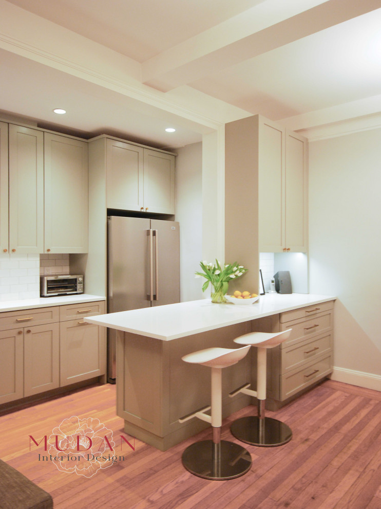 Example of a small transitional galley medium tone wood floor eat-in kitchen design with a farmhouse sink, shaker cabinets, gray cabinets, quartz countertops, ceramic backsplash, stainless steel appliances, a peninsula, white backsplash and white countertops