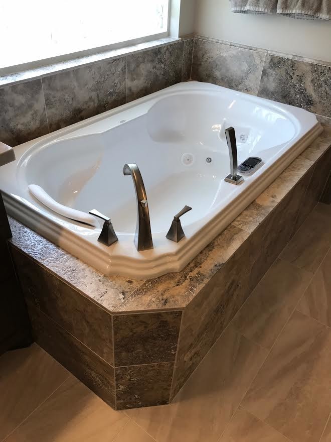 Design ideas for a mid-sized country master bathroom in Houston with a corner tub, a two-piece toilet, grey walls and beige floor.