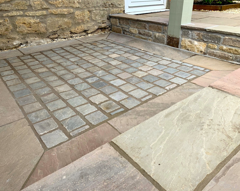 Inspiration for a mid-sized country courtyard patio in Other with natural stone pavers.