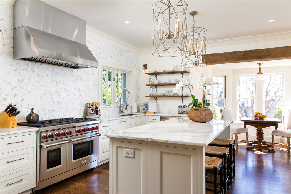 This is an example of a mid-sized country u-shaped eat-in kitchen in Birmingham with an undermount sink, white cabinets, with island, recessed-panel cabinets, marble benchtops, white splashback, marble splashback, panelled appliances, dark hardwood floors, brown floor and white benchtop.