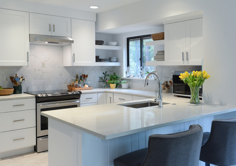 Photo of a contemporary u-shaped kitchen in Other with an undermount sink, shaker cabinets, white cabinets and white benchtop.