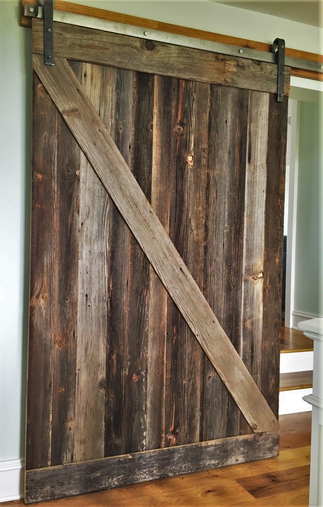 Mid-sized mountain style medium tone wood floor and brown floor hallway photo with brown walls