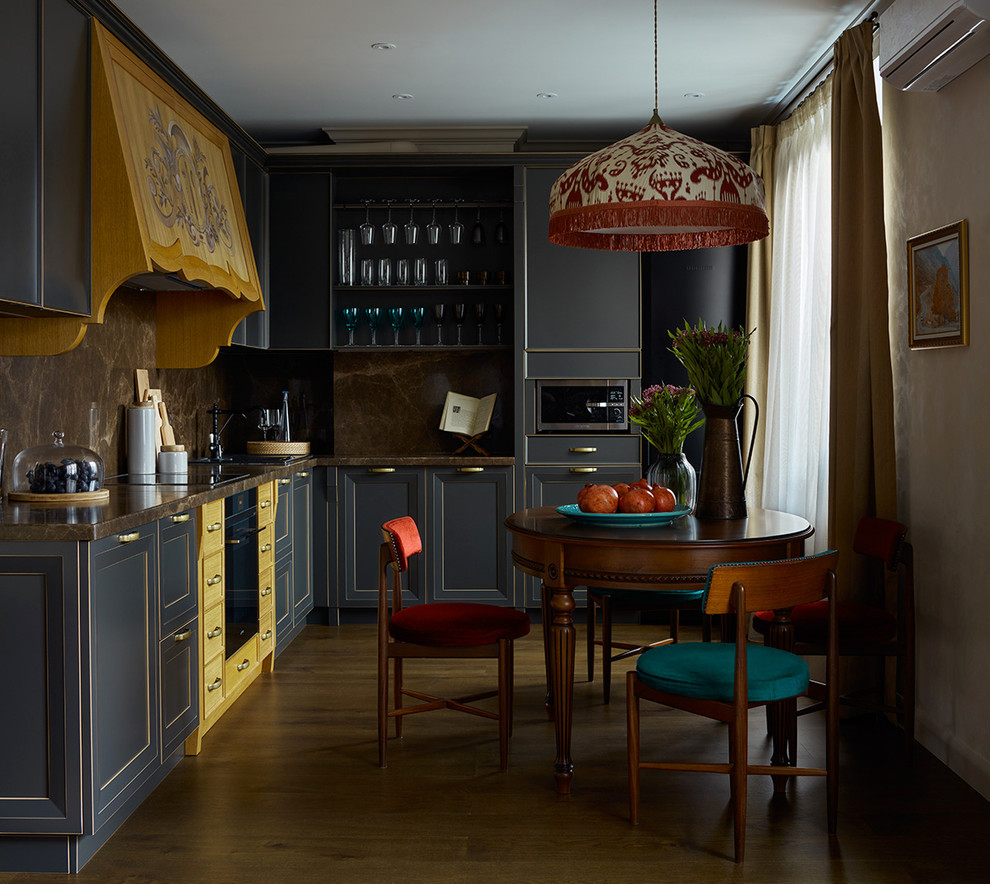 Inspiration for a mid-sized eclectic l-shaped eat-in kitchen in Moscow with recessed-panel cabinets, grey cabinets, brown splashback, black appliances, no island, marble benchtops and dark hardwood floors.