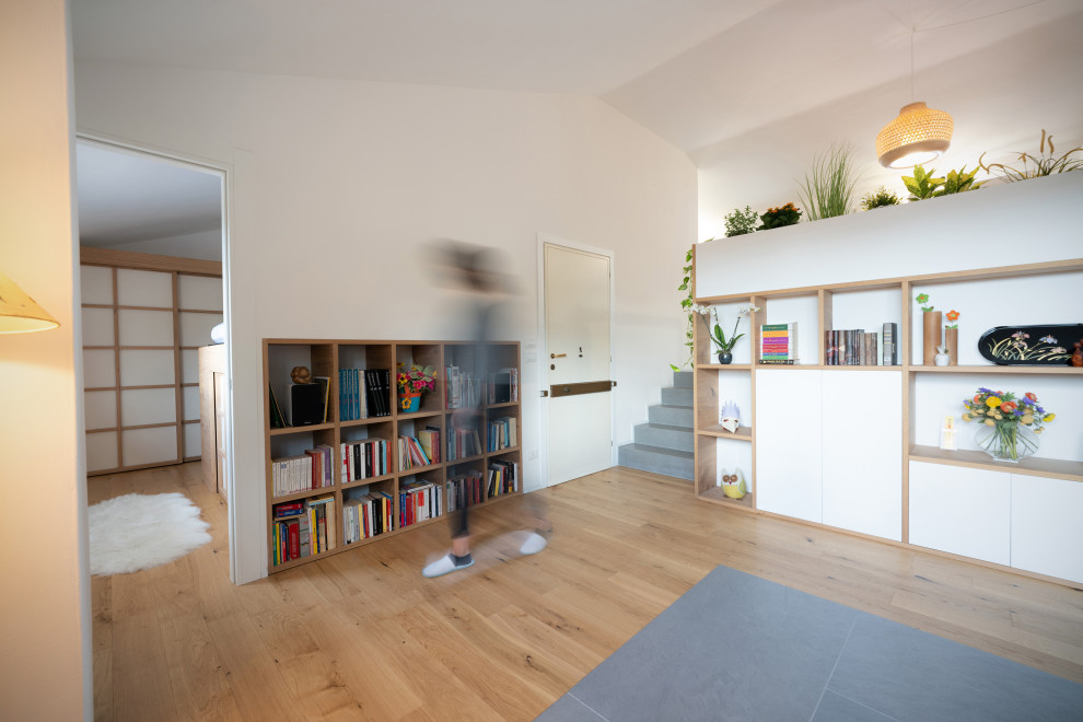 На фото: маленькая изолированная гостиная комната в восточном стиле с с книжными шкафами и полками, белыми стенами, татами и серым полом без камина, телевизора для на участке и в саду