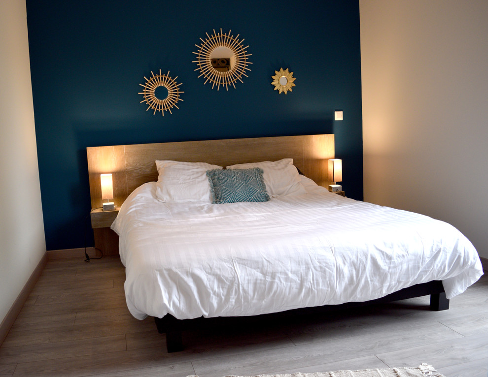 Idées déco pour une chambre parentale scandinave de taille moyenne avec un mur bleu, parquet clair et un sol beige.