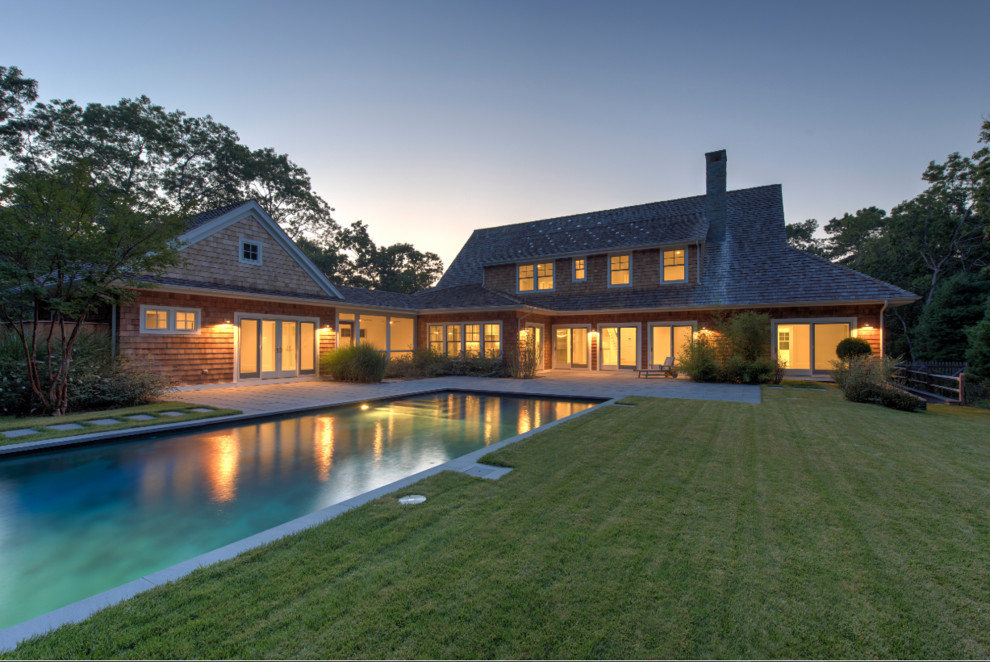 Large transitional three-story and backyard mixed siding, concrete paver and rectangular lap pool photo