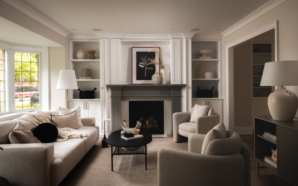Example of a transitional medium tone wood floor and brown floor living room design in Toronto with beige walls and a standard fireplace