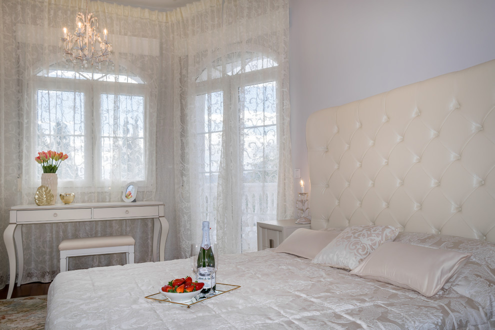 Ejemplo de dormitorio principal clásico renovado grande con paredes grises y suelo de madera en tonos medios