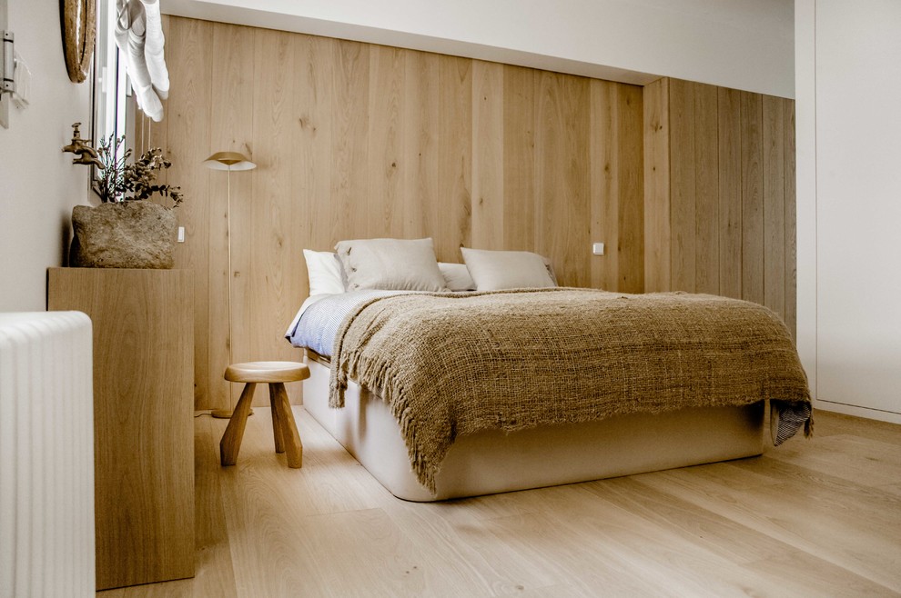 Diseño de dormitorio principal mediterráneo de tamaño medio con paredes marrones, suelo de madera clara, marco de chimenea de madera, suelo marrón y chimenea de esquina