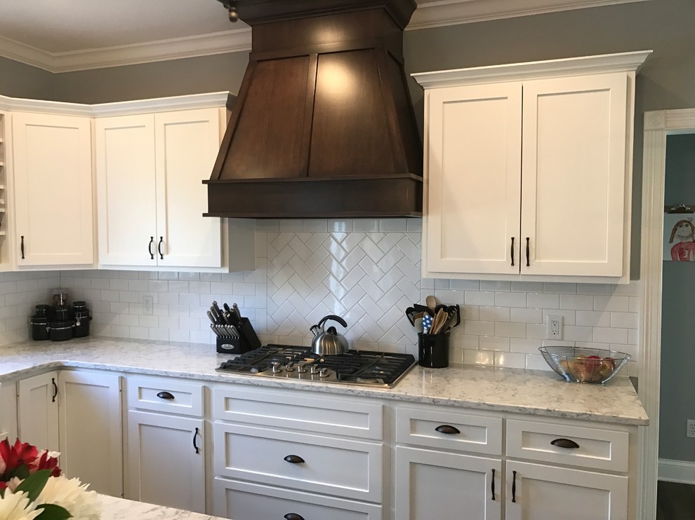 Country u-shaped eat-in kitchen in Other with a farmhouse sink, shaker cabinets, white cabinets, quartzite benchtops, white splashback, subway tile splashback, stainless steel appliances, laminate floors and with island.