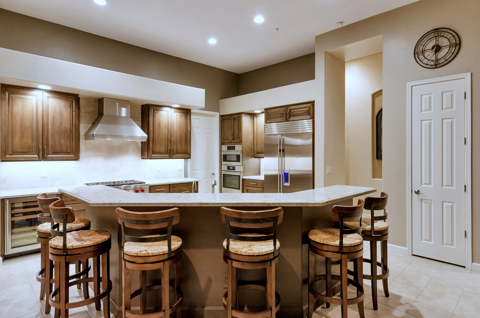 Inspiration for a large transitional l-shaped ceramic tile and white floor open concept kitchen remodel in Phoenix with raised-panel cabinets, medium tone wood cabinets, solid surface countertops, white backsplash, stainless steel appliances and an island