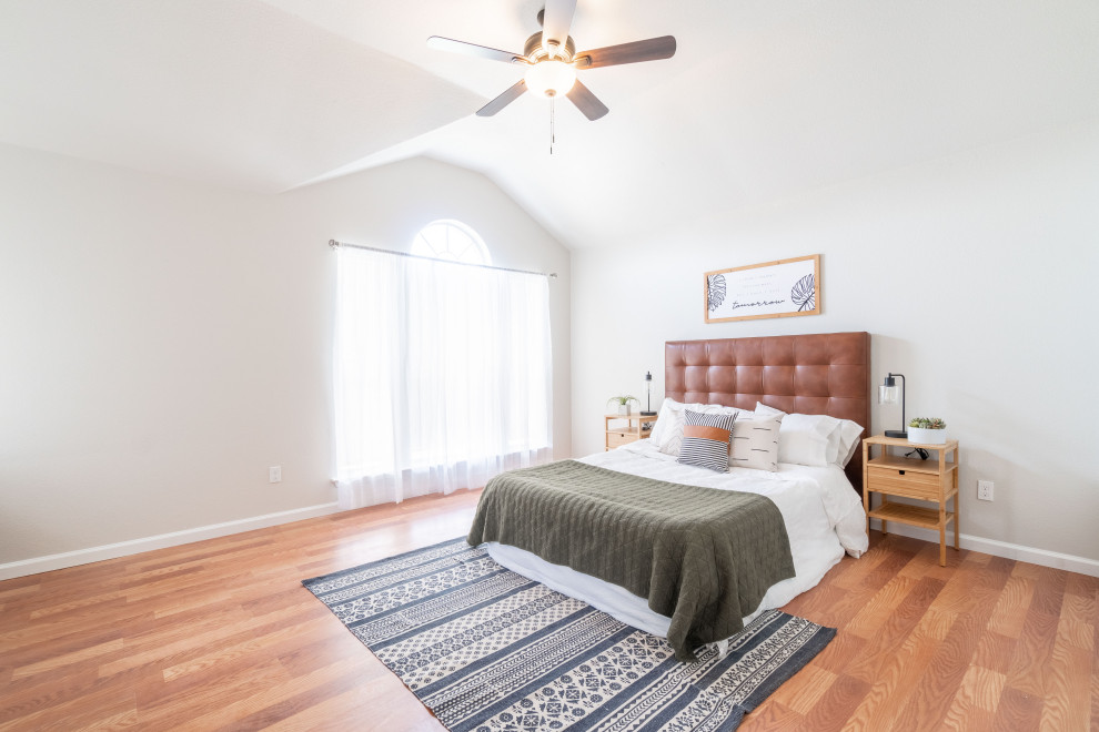 Mid-sized contemporary master bedroom in Dallas with beige walls, vinyl floors, a standard fireplace, a brick fireplace surround and brown floor.
