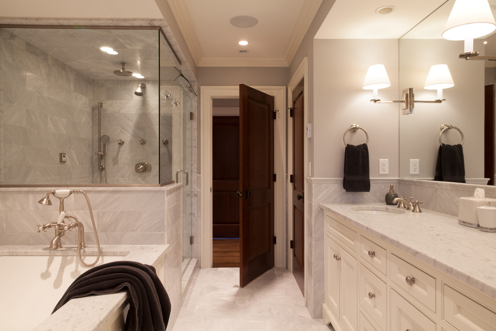 Inspiration for a large traditional master bathroom in Boston with beaded inset cabinets, white cabinets, an undermount tub, a shower/bathtub combo, a one-piece toilet, white tile, marble, beige walls, marble floors, an undermount sink, marble benchtops, white floor and a hinged shower door.
