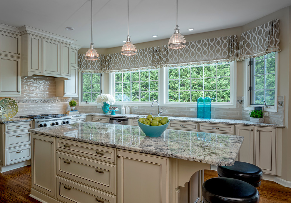 Example of a large transitional medium tone wood floor and brown floor kitchen design in Baltimore with an undermount sink, recessed-panel cabinets, beige cabinets, granite countertops, beige backsplash, ceramic backsplash, stainless steel appliances and an island