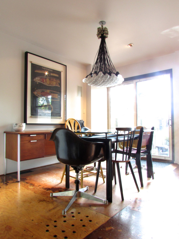 This is an example of a traditional dining room in Toronto with plywood floors.