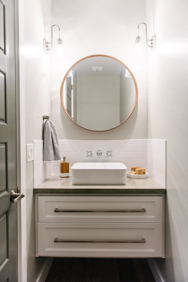 Inspiration for a small transitional powder room in Salt Lake City with furniture-like cabinets, white cabinets, white tile, subway tile, grey walls, ceramic floors, a vessel sink and concrete benchtops.