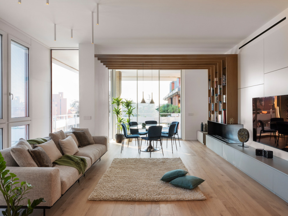 This is an example of a large contemporary open concept living room in Milan with white walls, medium hardwood floors, a metal fireplace surround, a wall-mounted tv, beige floor and recessed.