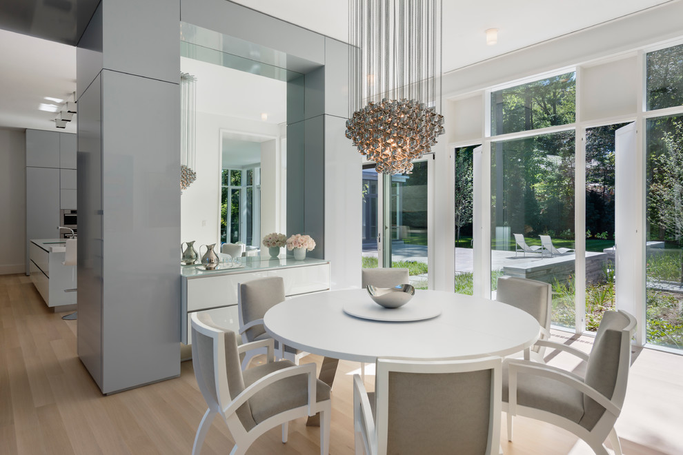 This is an example of a contemporary dining room in Boston with light hardwood floors.