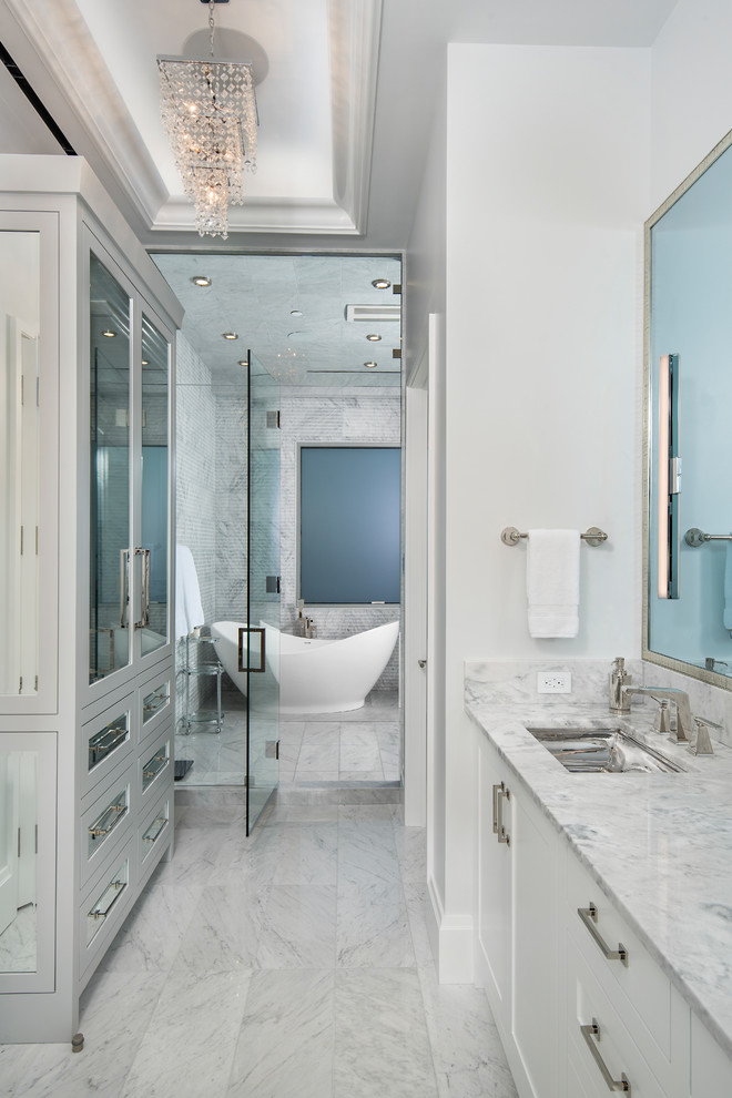 Design ideas for a large transitional master wet room bathroom in Austin with shaker cabinets, white cabinets, a freestanding tub, white tile, mosaic tile, white walls, marble floors, an undermount sink, quartzite benchtops, white floor, a hinged shower door and white benchtops.