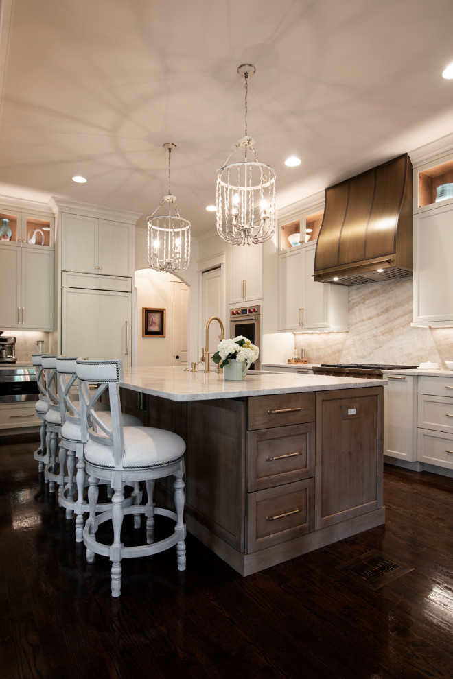 Open concept kitchen - large transitional l-shaped dark wood floor and brown floor open concept kitchen idea in Nashville with an undermount sink, beaded inset cabinets, white cabinets, quartzite countertops, beige backsplash, stone slab backsplash, stainless steel appliances, an island and beige countertops