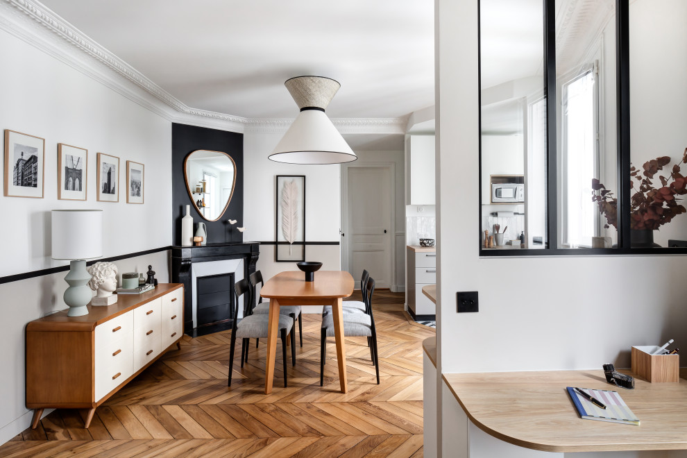 Inspiration pour une salle à manger ouverte sur le salon minimaliste de taille moyenne avec un mur beige, parquet clair, une cheminée standard, un manteau de cheminée en pierre et un sol marron.