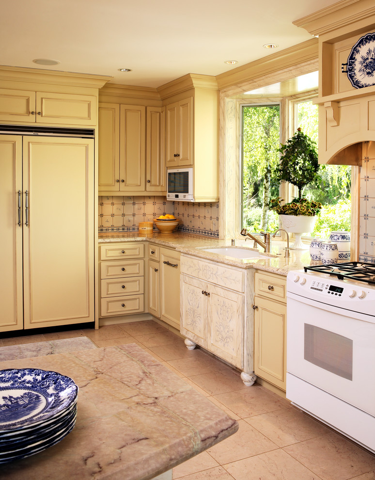 Mid-sized traditional l-shaped separate kitchen in San Francisco with a drop-in sink, yellow cabinets, marble benchtops, blue splashback, ceramic splashback, panelled appliances and marble floors.