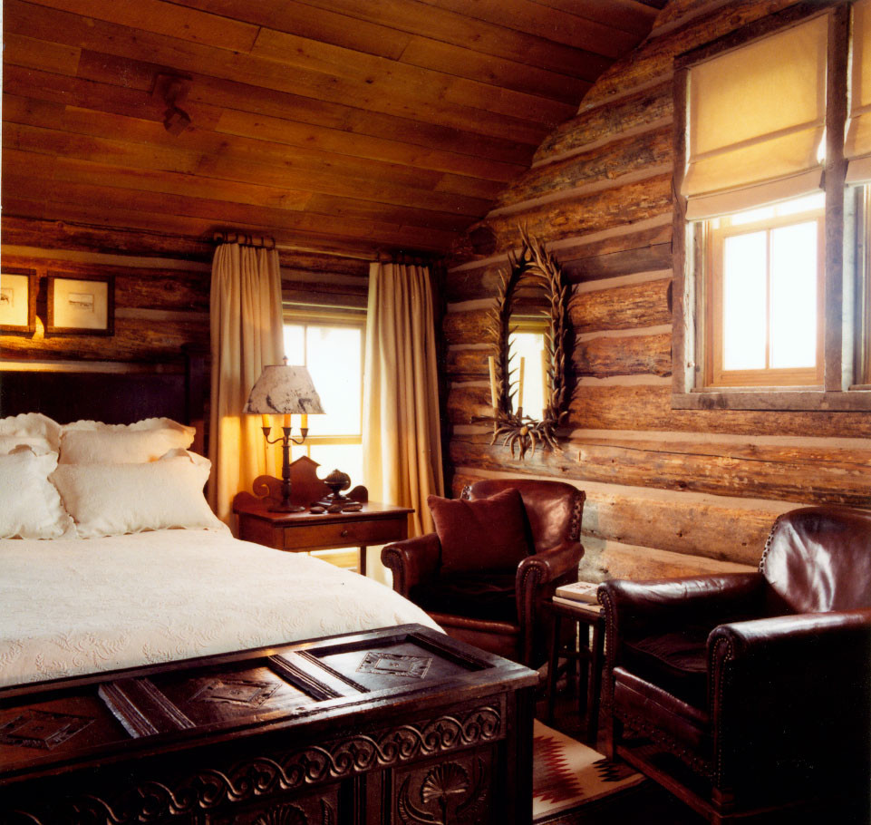 This is an example of a country loft-style bedroom in Other with dark hardwood floors.