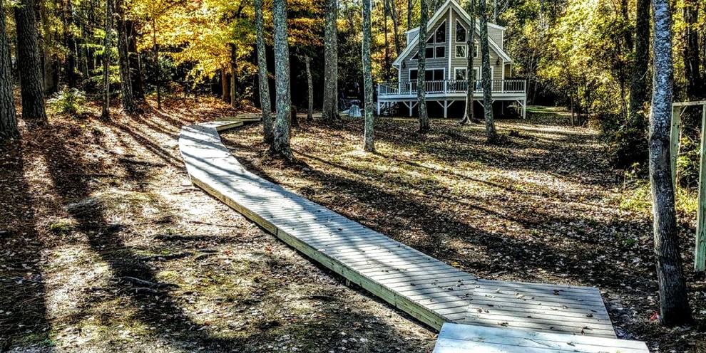 Inspiration for a huge rustic partial sun backyard walkway with decking for fall.