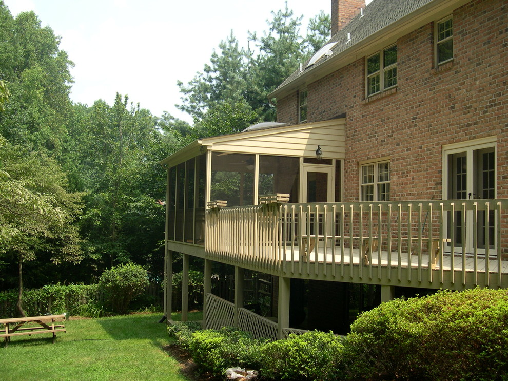Example of a mid-sized mountain style backyard deck design in Baltimore with a roof extension