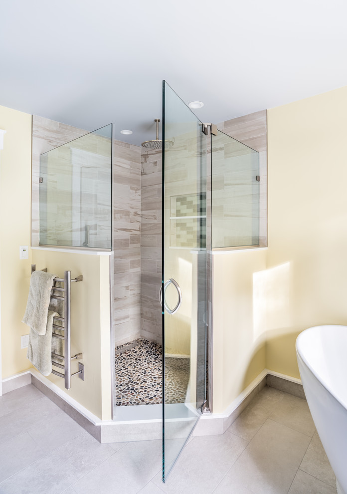 Inspiration for a large contemporary master bathroom in New York with recessed-panel cabinets, medium wood cabinets, a freestanding tub, a corner shower, a one-piece toilet, multi-coloured tile, porcelain tile, yellow walls, porcelain floors, an undermount sink, quartzite benchtops, grey floor and a hinged shower door.