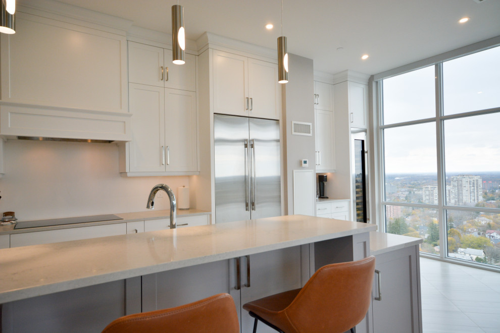 Example of a mid-sized transitional open concept kitchen design in Toronto with shaker cabinets, white cabinets, quartz countertops, stainless steel appliances, a peninsula and white countertops