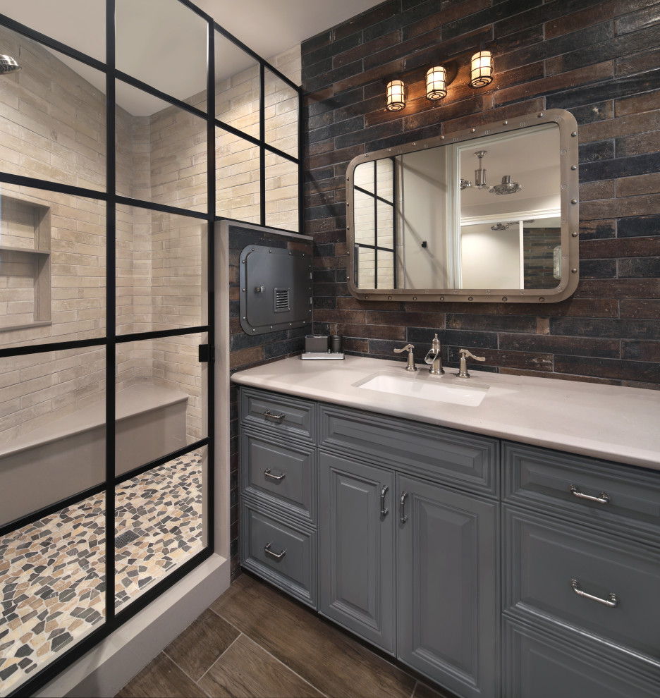 Design ideas for a mid-sized beach style 3/4 bathroom in Orange County with grey cabinets, a hinged shower door, white benchtops, raised-panel cabinets, an alcove shower, brown tile, gray tile, an undermount sink, brown floor, a niche and a single vanity.