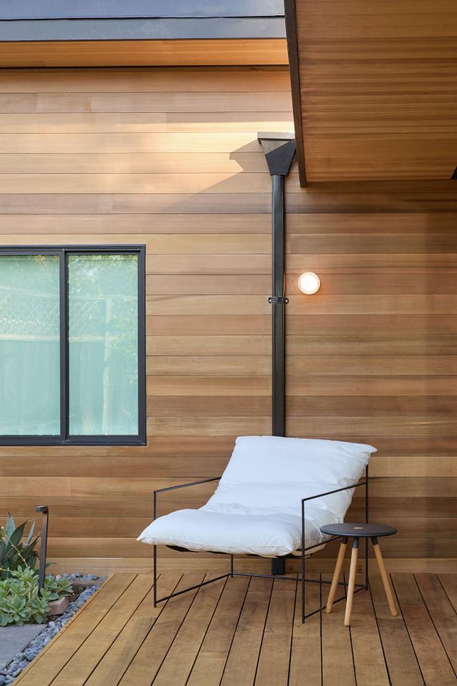 Deck - mid-sized mid-century modern backyard ground level deck idea in San Francisco with a roof extension