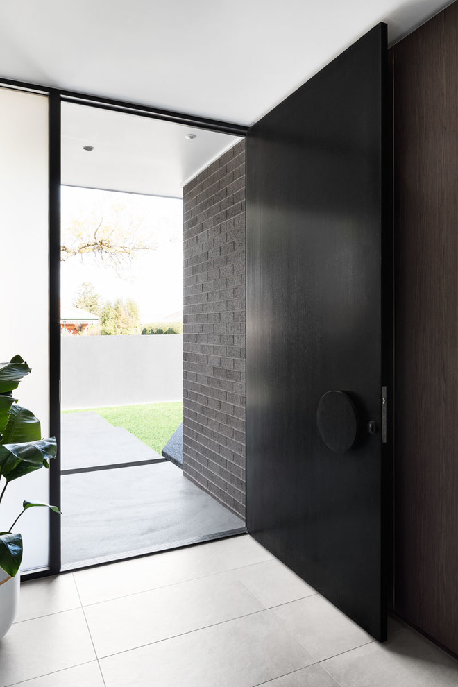 Design ideas for a contemporary entryway in Melbourne with ceramic floors, a single front door, a black front door and grey floor.