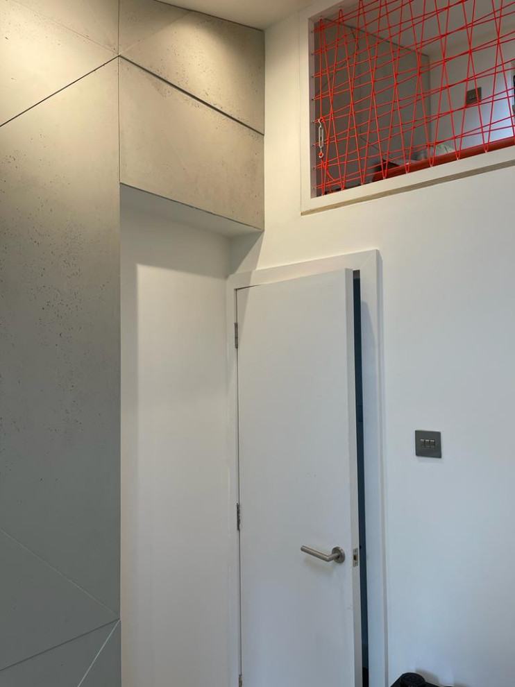 На фото: серо-белая спальня на антресоли в современном стиле с белыми стенами, светлым паркетным полом, сводчатым потолком, панелями на части стены и акцентной стеной с