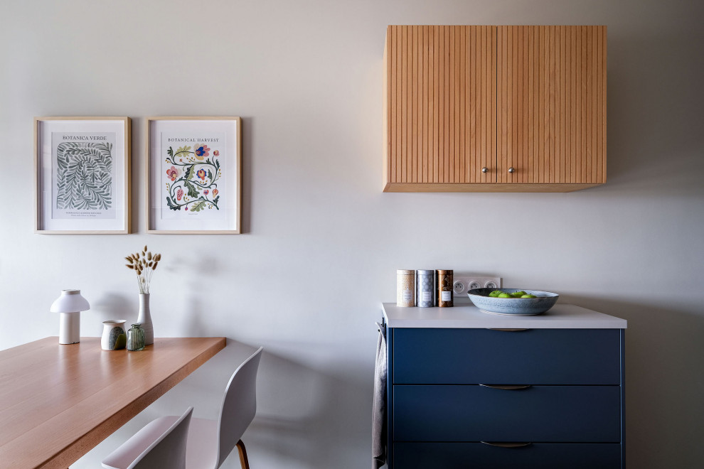 Réalisation d'une cuisine linéaire design de taille moyenne avec un placard à porte plane, des portes de placard bleues, carreaux de ciment au sol, un sol multicolore, un plan de travail gris et machine à laver.