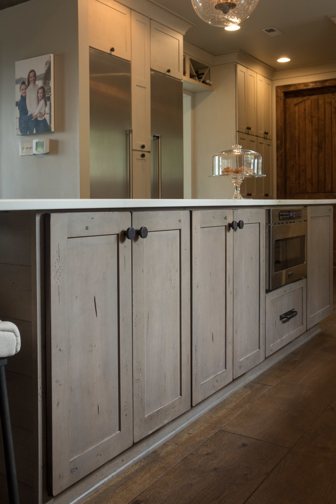Example of a large transitional galley dark wood floor and brown floor open concept kitchen design with a farmhouse sink, shaker cabinets, quartz countertops, brown backsplash, brick backsplash, stainless steel appliances and an island